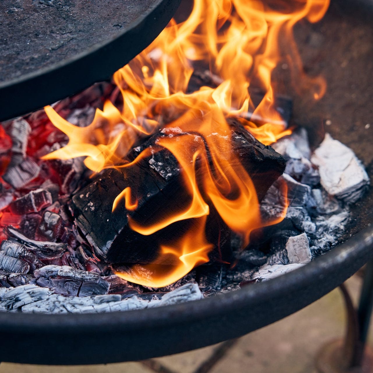 Charcoal grill with flames and glowing embers