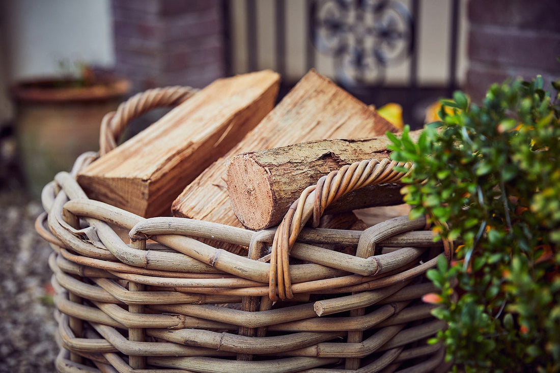 Kiln-dried firewood logs stacked in a wicker basket outside a UK home, ready to burn