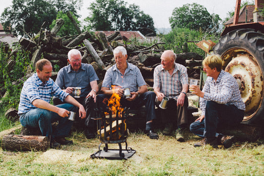 Gathered round a fire outdoors