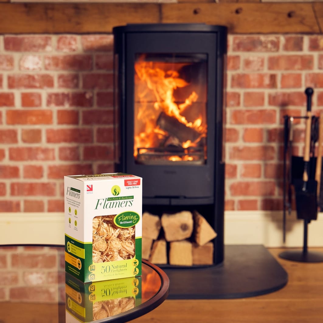 A box of Flamers natural firelighters in front of a lit woodburner