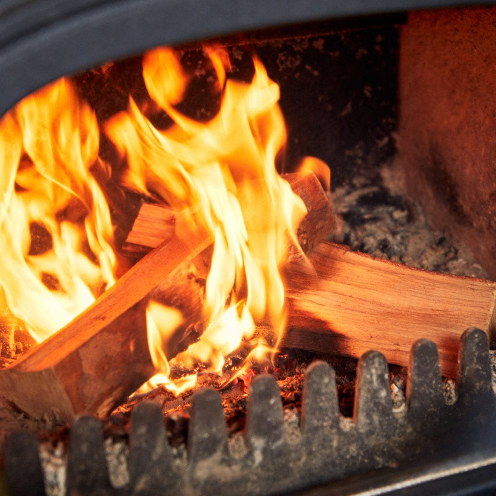 Wood burning in a fireplace with flames and glowing embers.