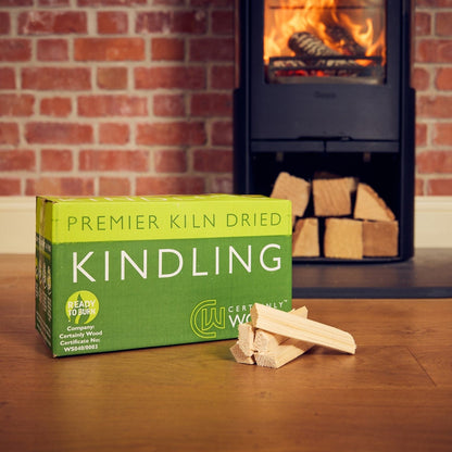 Box of Wickersham Kindling with kindling sticks in front of a fireplace.