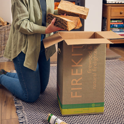 Person opening a Firekit box with firewood and firelighters.