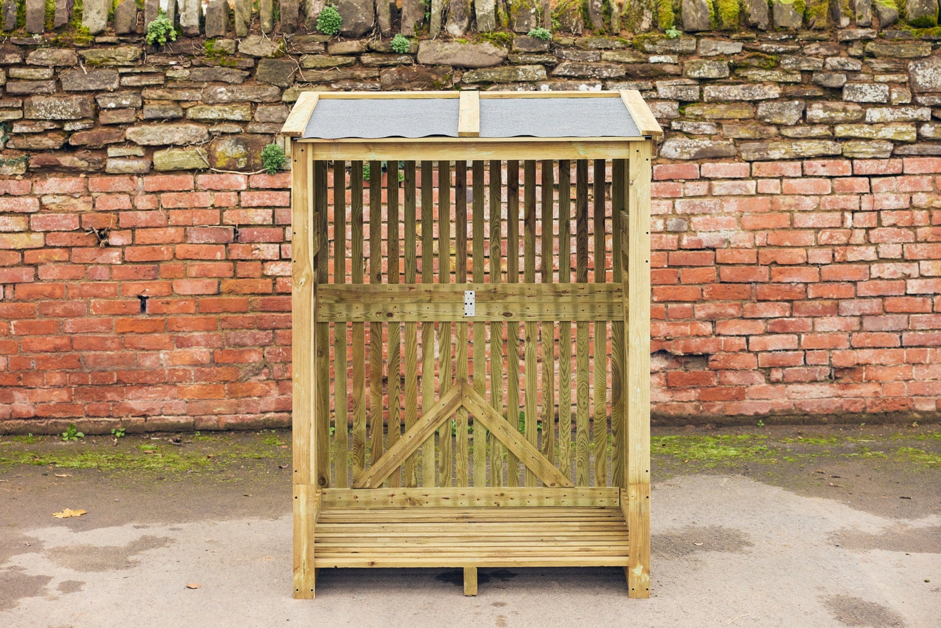 a pressure treated log store with a felt roof empty and ready to be filled with firewood