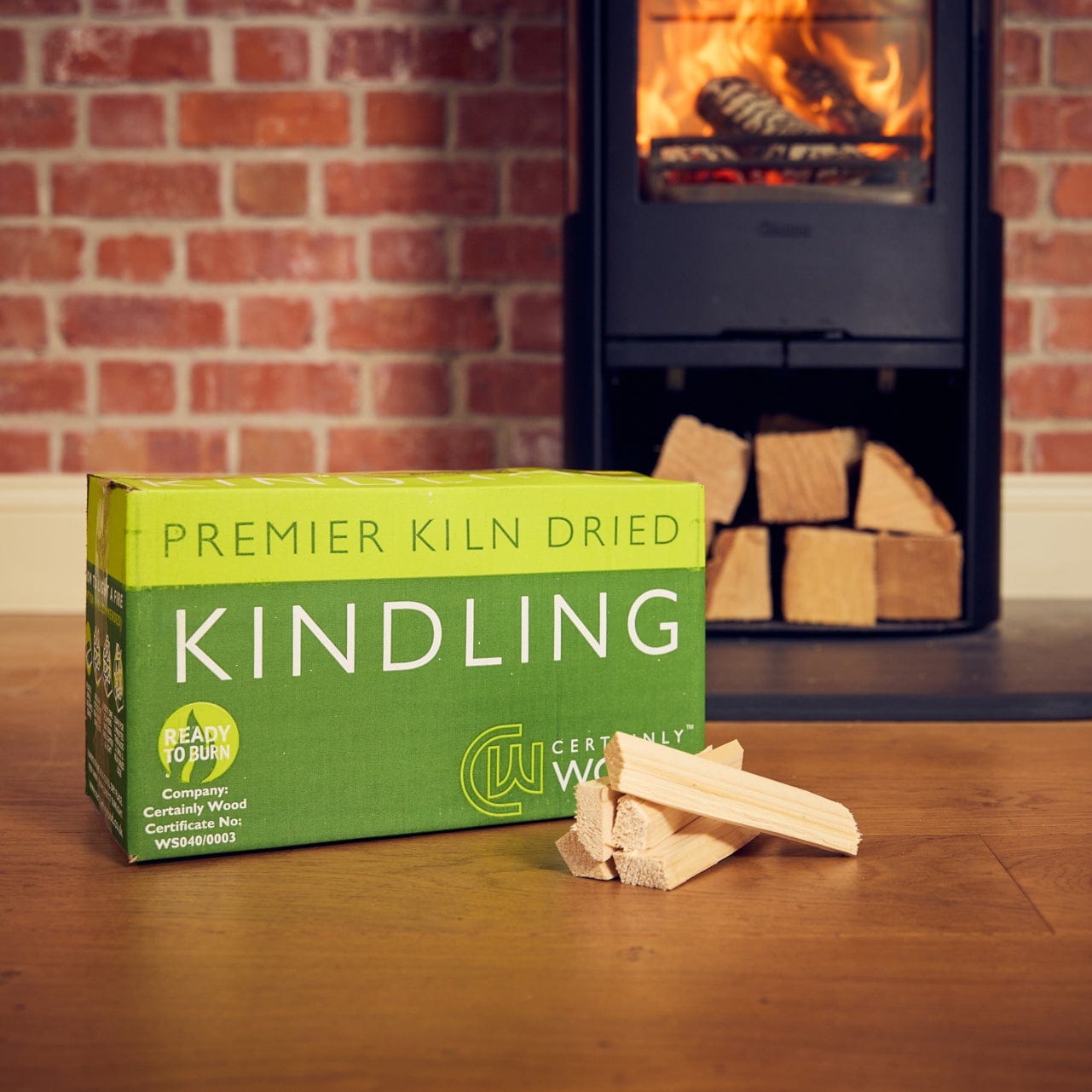 Box of Certainly Wood Kindling with kindling sticks in front of a fireplace.