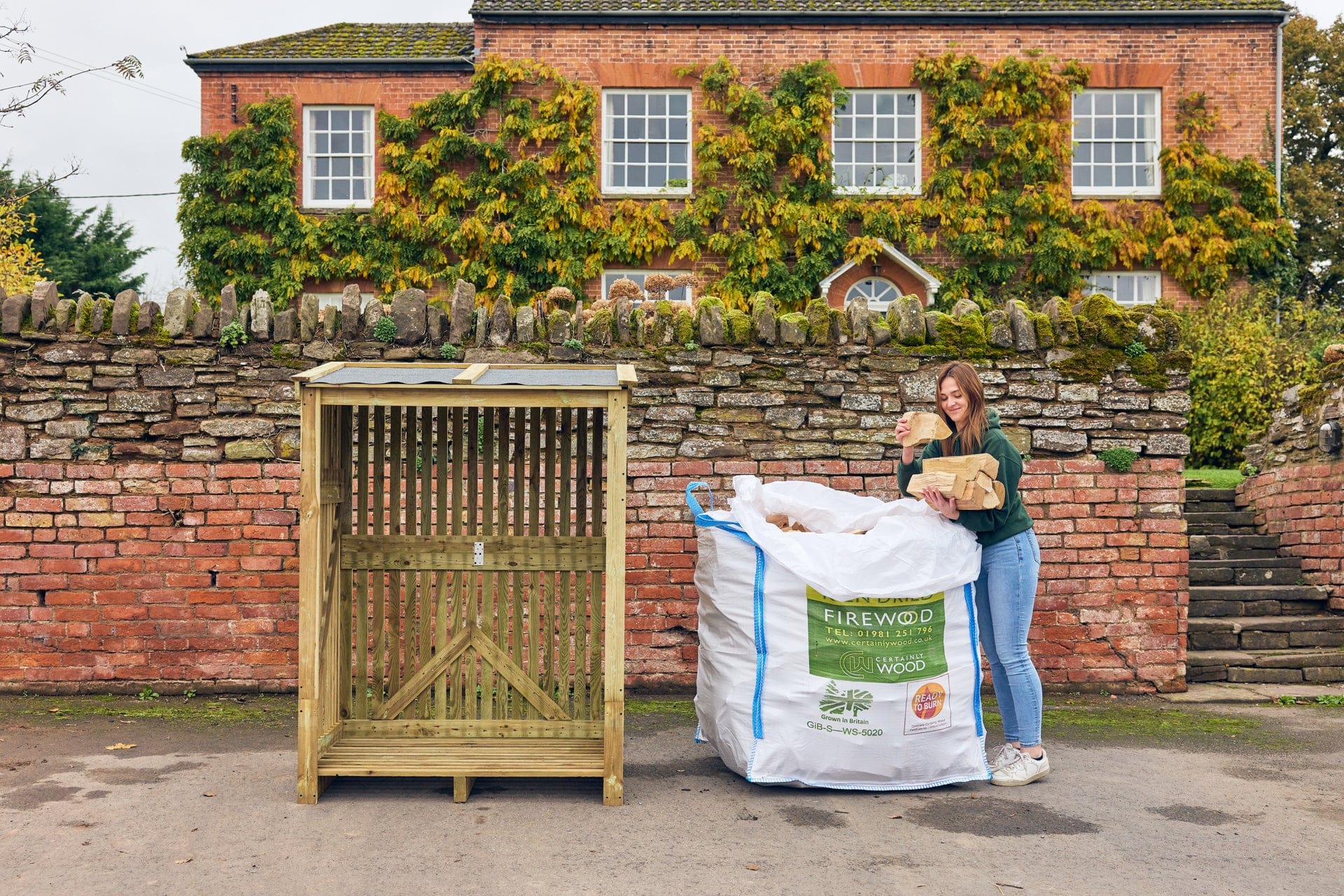 a lady unpacking her bulk bag of firewood ready for her a log store